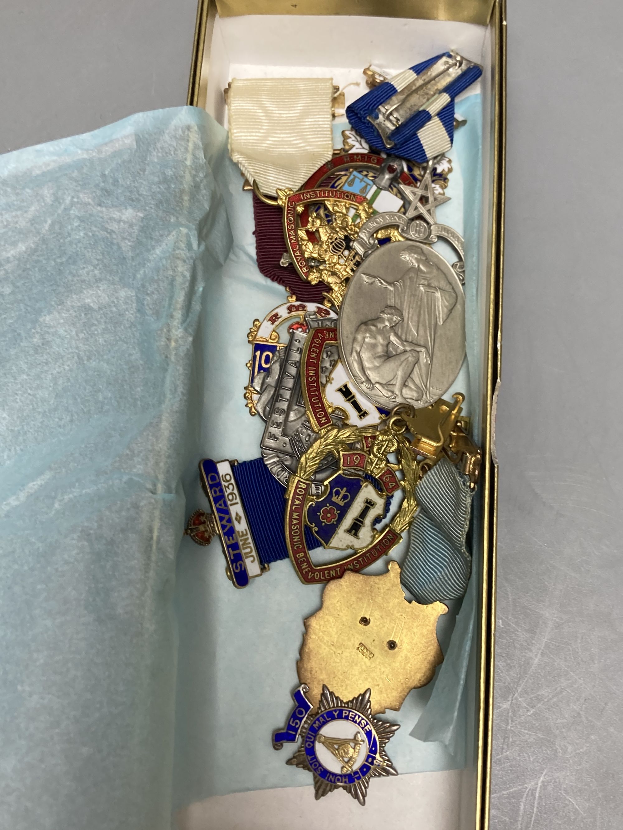 A collection of assorted enamel badges and nursing badges